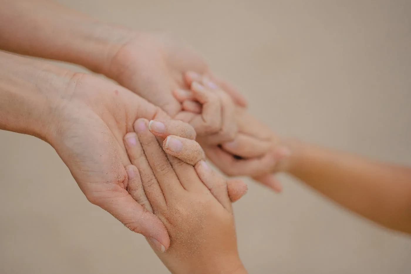 An adult’s hand gently holding a child’s smaller hand